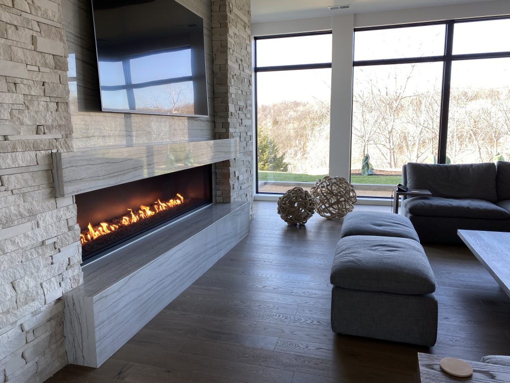 Cozy living room with fireplace and expansive windows,