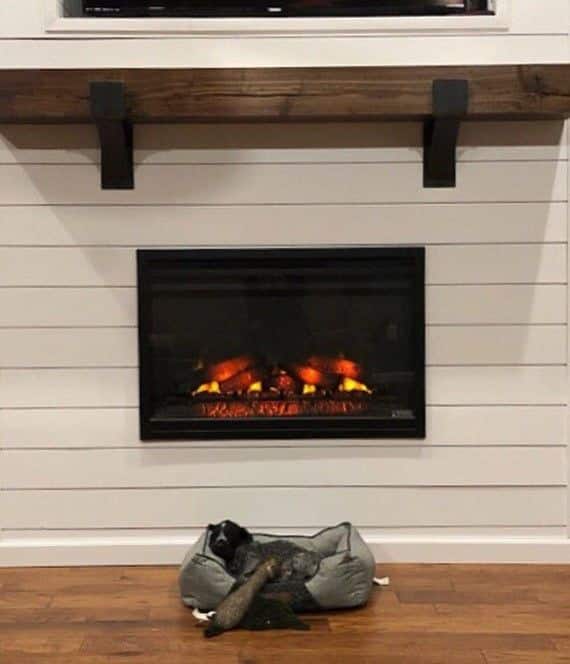 A simple white wooden mantel with a fireplace beneath it