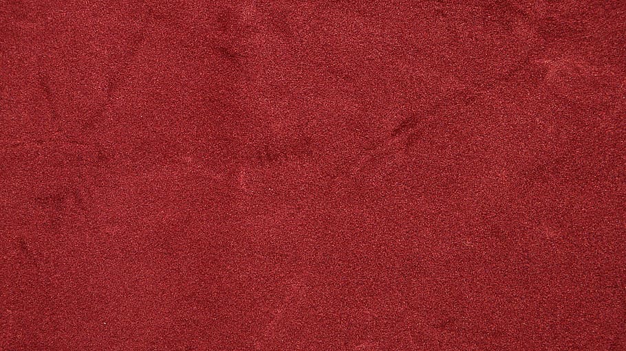 A close-up of a red fabric texture background, showcasing the rich and vibrant color of velve