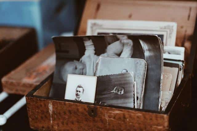 A vintage brown wooden box with black and white photos.