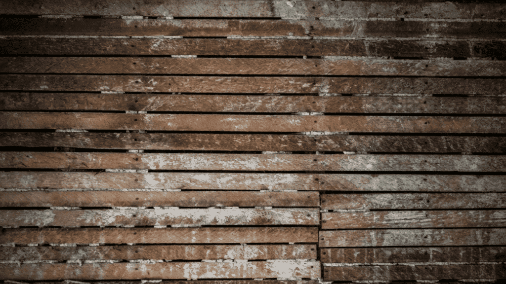 aged wood lath strips with dried plaster residue showing the horizontal framework used in lath and plaster walls