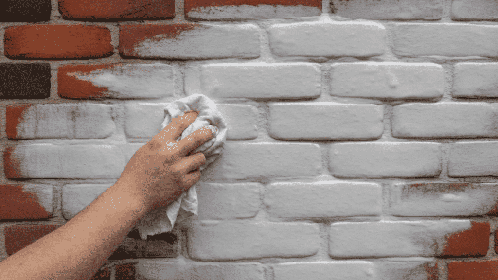 removing excess lime wash from the wall using a rag
