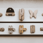 a flat lay of multiple hinge types including concealed butt butterfly strap and soft-close hinges arranged on a light grey surface