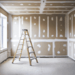 a room with beige drywall showing mudded seams, with a ladder as the drywall installation progresses