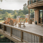 spacious wooden backyard deck with outdoor chairs and railing overlooking green landscape