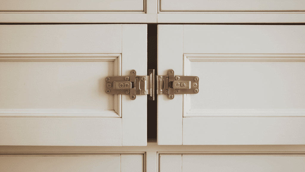 surface mount cabinet hinges on white face frame doors showing both silver hinge leaves mounted flat on the cabinet door surface